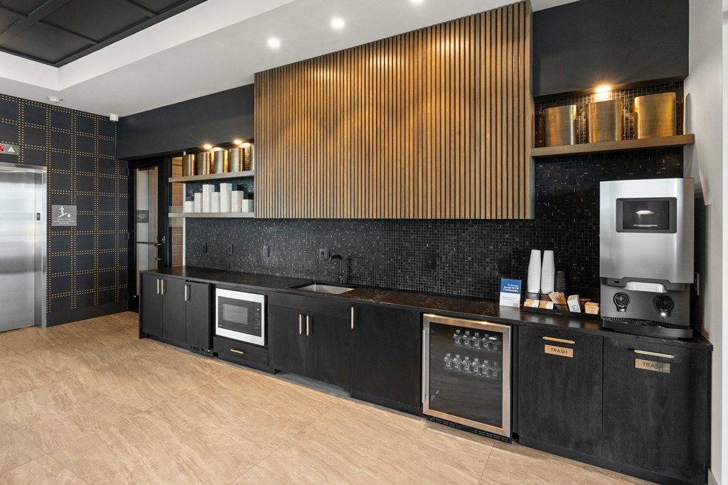 a kitchen with black cabinets and a wood floor