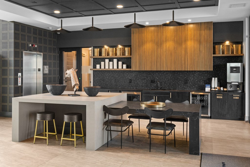 a kitchen with a counter and chairs in it