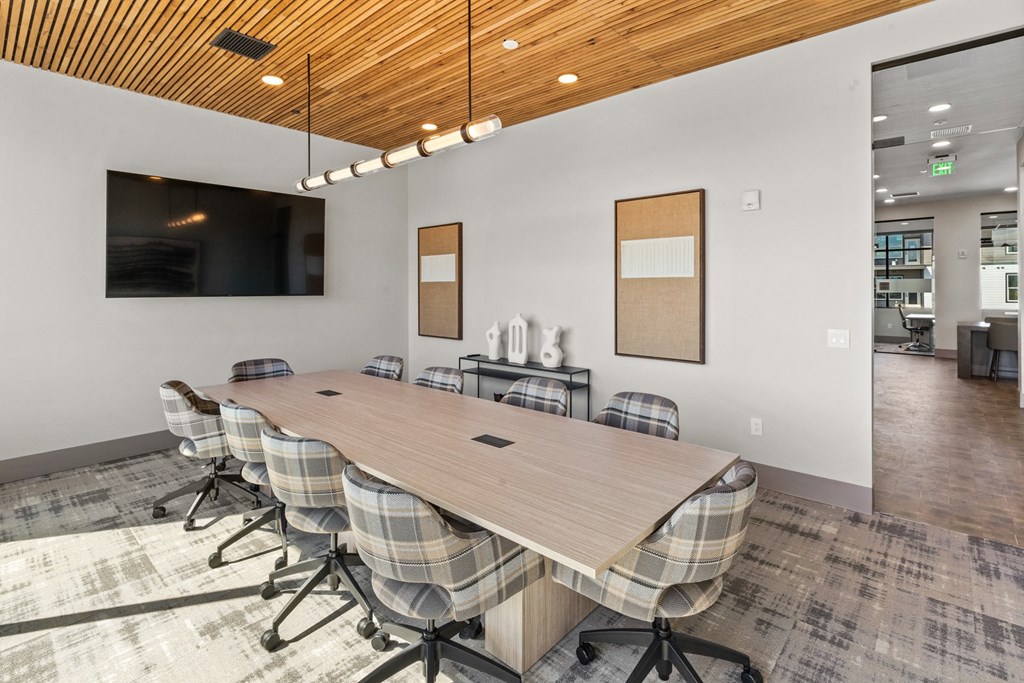 a conference room with a large wooden table and chairs and a tv