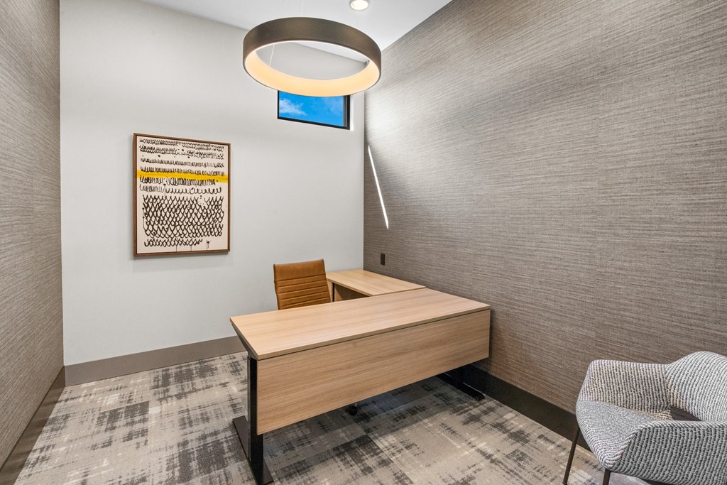 a desk in a room with a chair and a lamp