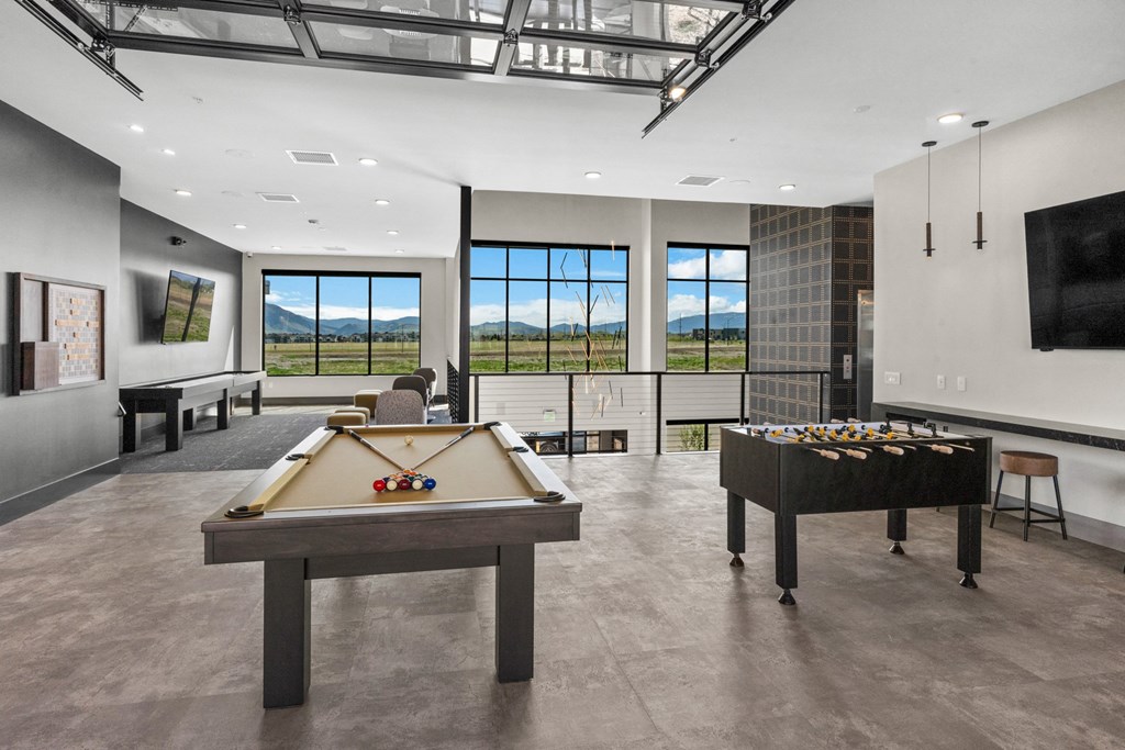 a games room with two pool tables and a tv