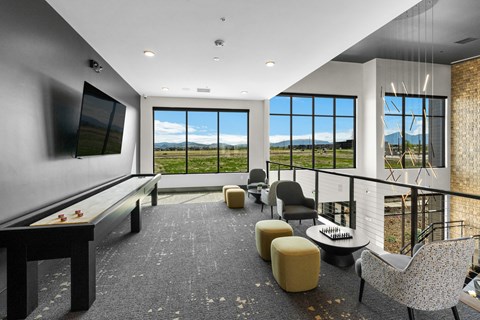 a living room with a desk and chairs and a television