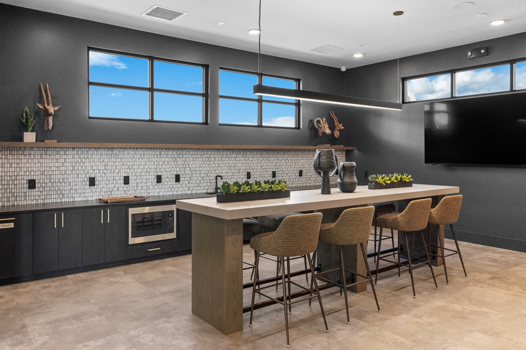 a kitchen with a large island with chairs and a counter top