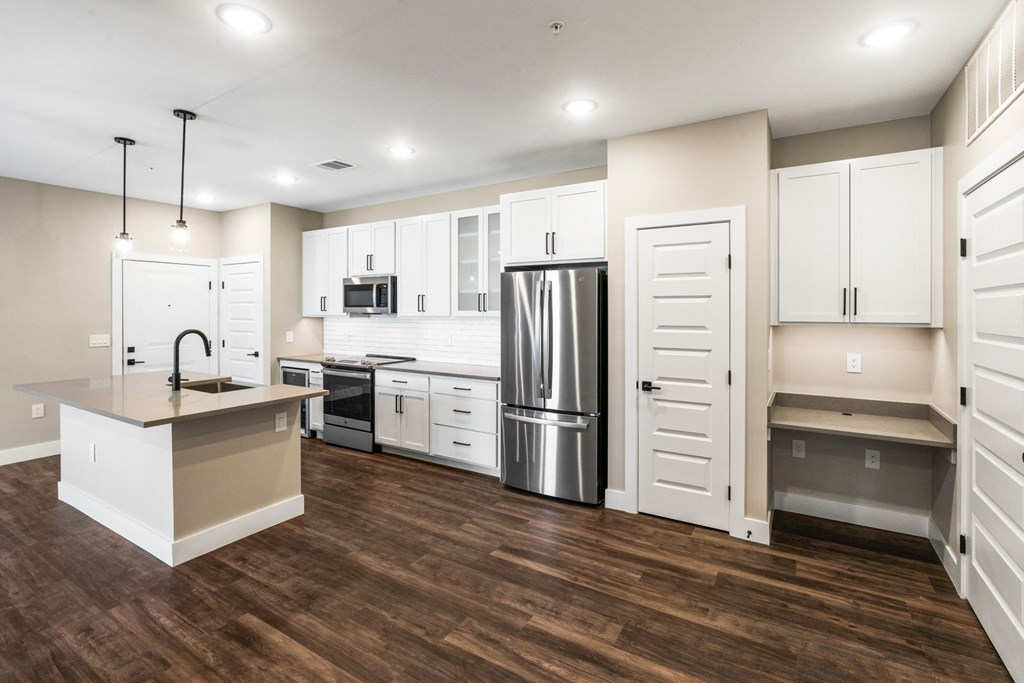 a kitchen with white cabinets and a stainless steel refrigerator