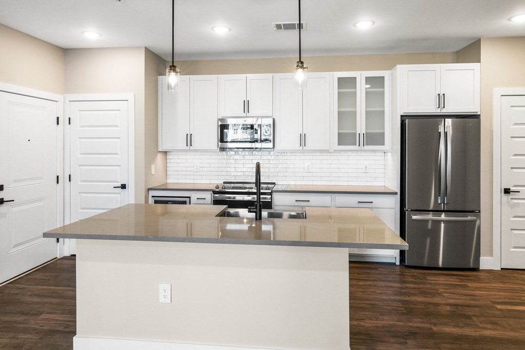 a large kitchen with white cabinets and stainless steel appliances
