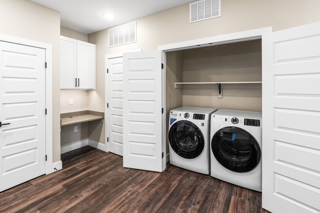 a laundry room with white cabinets and a washer and dryer