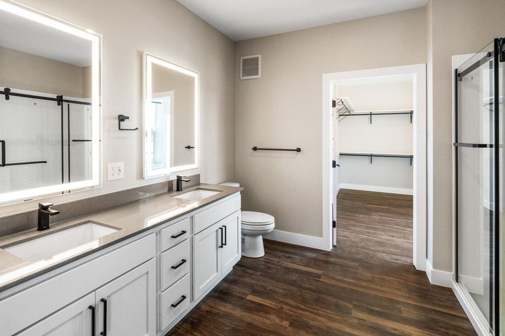 a bathroom with white cabinets and a toilet and a shower