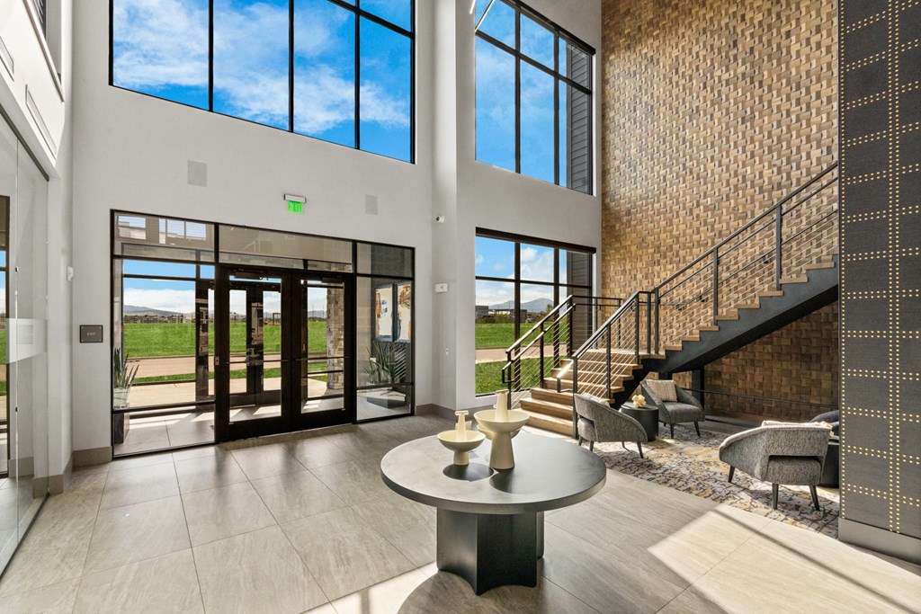 the foyer of a modern home with large windows and a table