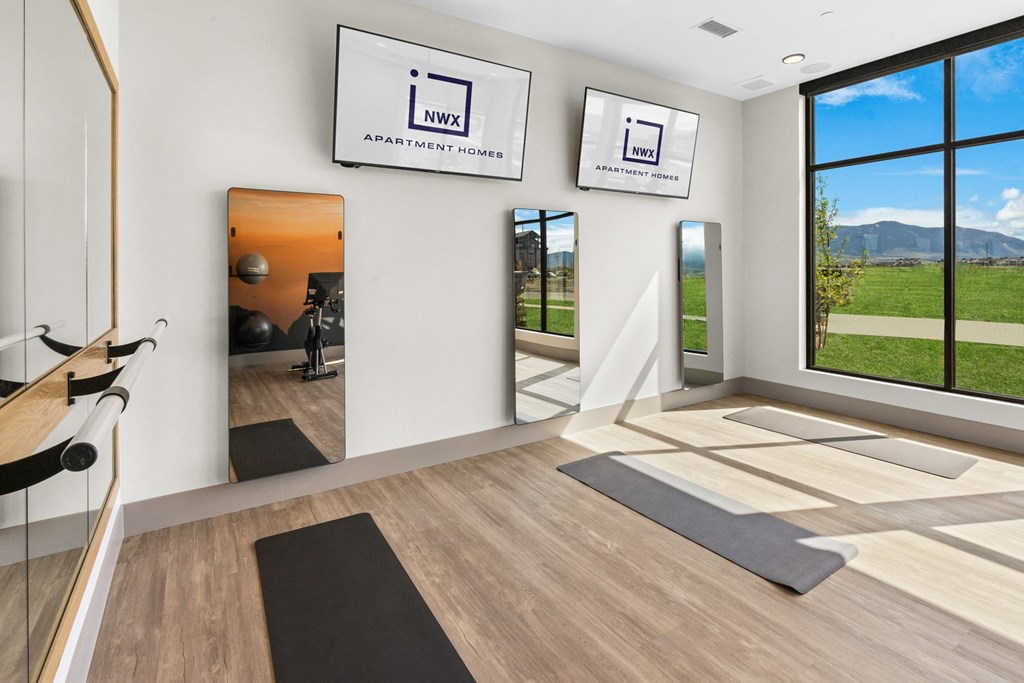 a yoga room with mirrors and yoga mats on the floor