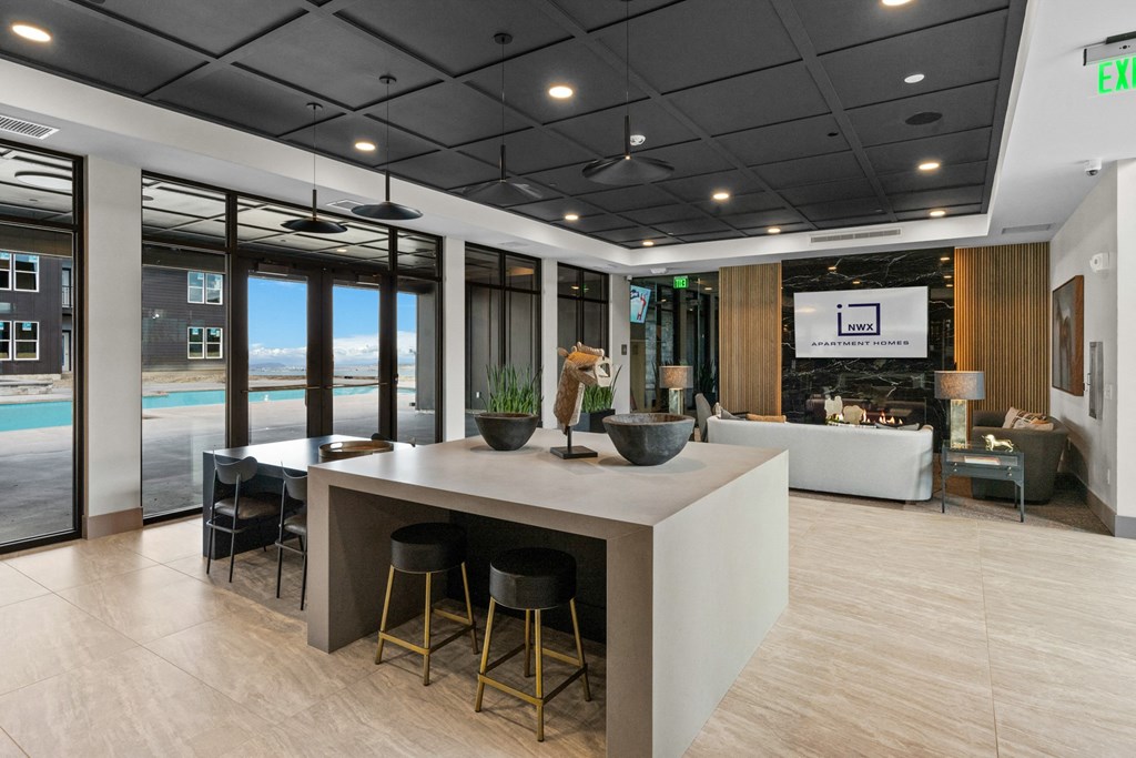 a large kitchen with a center island and stools in a lobby of a building