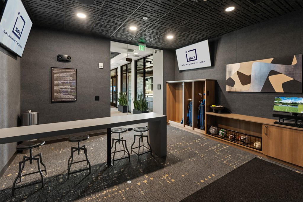 a lobby with a counter and stools and a television