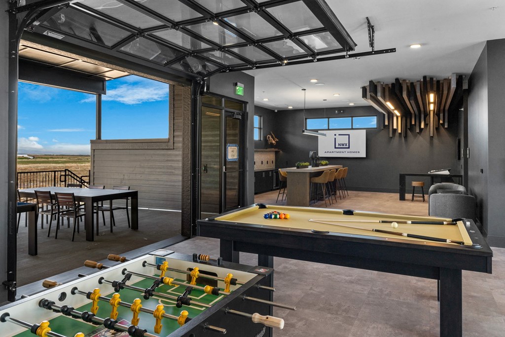 a games room with a pool table and a bar