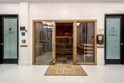 The entrance to a building with a glass door and a wooden door.