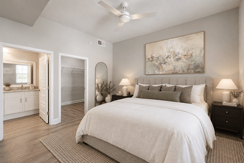 A bedroom with a large bed and a painting on the wall.