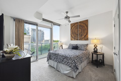 A bedroom with a large bed and a ceiling fan.