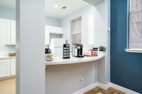 a kitchen with a counter with coffee machines and a window