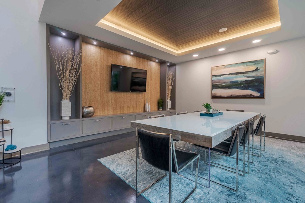 A modern dining room with a wooden ceiling and a large painting on the wall.