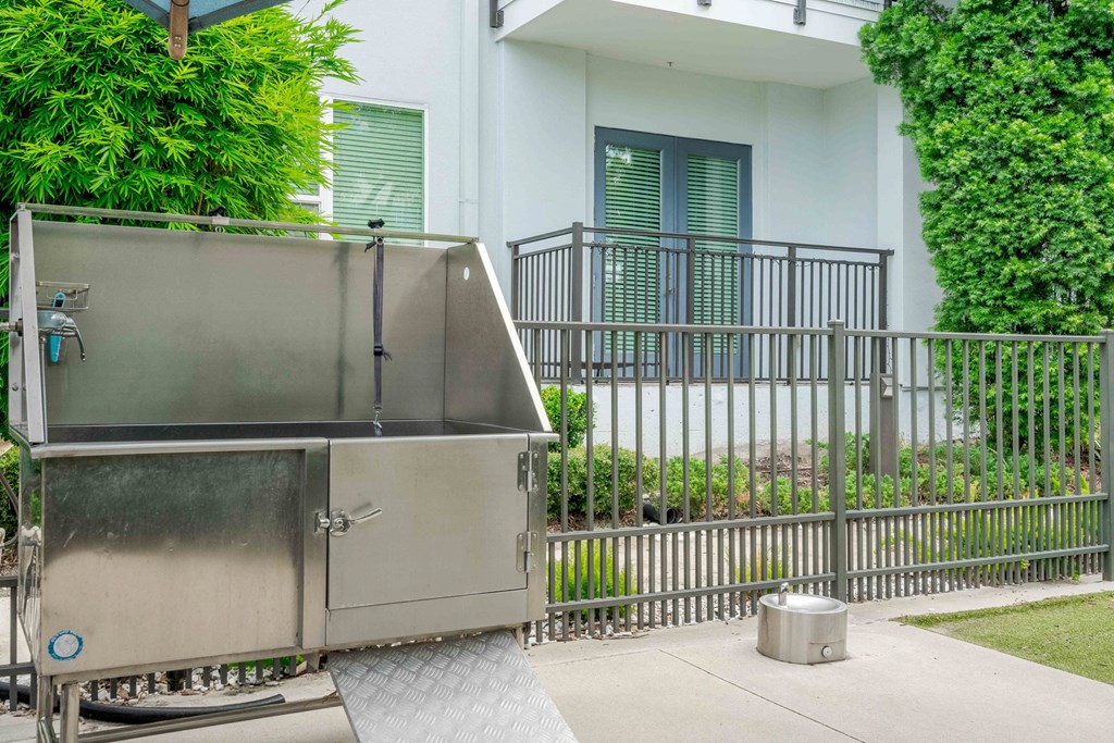 A stainless steel dishwasher is parked on a concrete driveway.