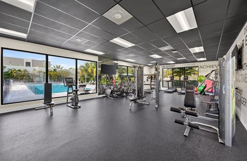 A gym with a variety of equipment and a sign that says "ACHIEVE".