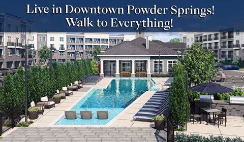 a pool with lounge chairs and a building with the words live in downtown powder springs