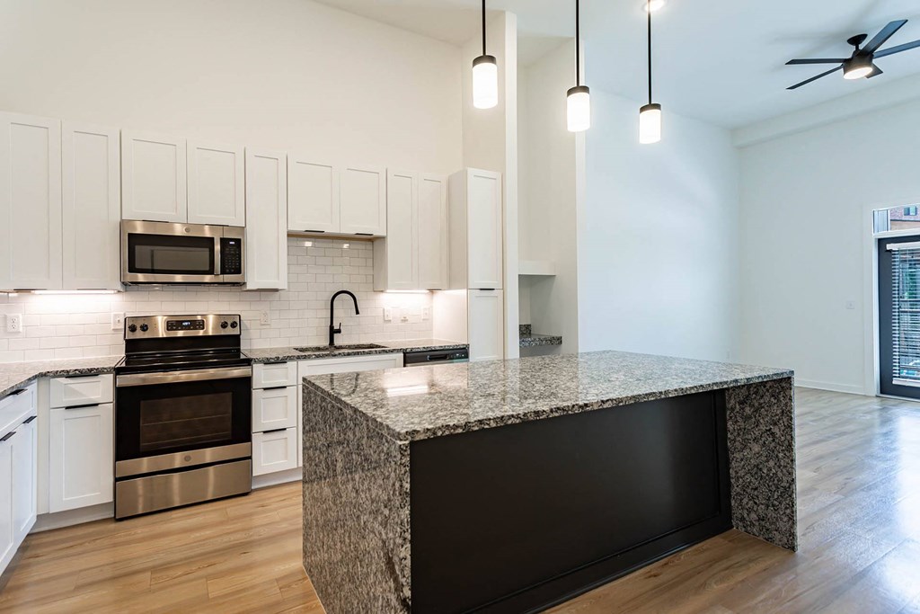 a kitchen with white cabinets and a granite counter top