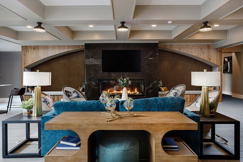 A modern living room with a fireplace and a blue couch.