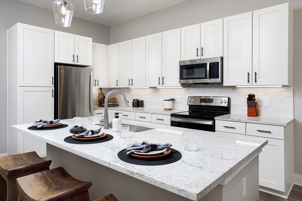 West Oakland Park, TN Pet-Friendly Luxury Apartments - Vintage Johnson City - A Kitchen with Stainless Steel Appliances and Marble Island.