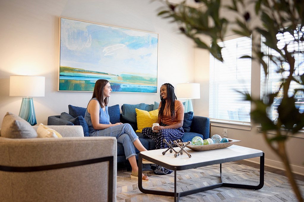 two women sitting on a couch in a living room