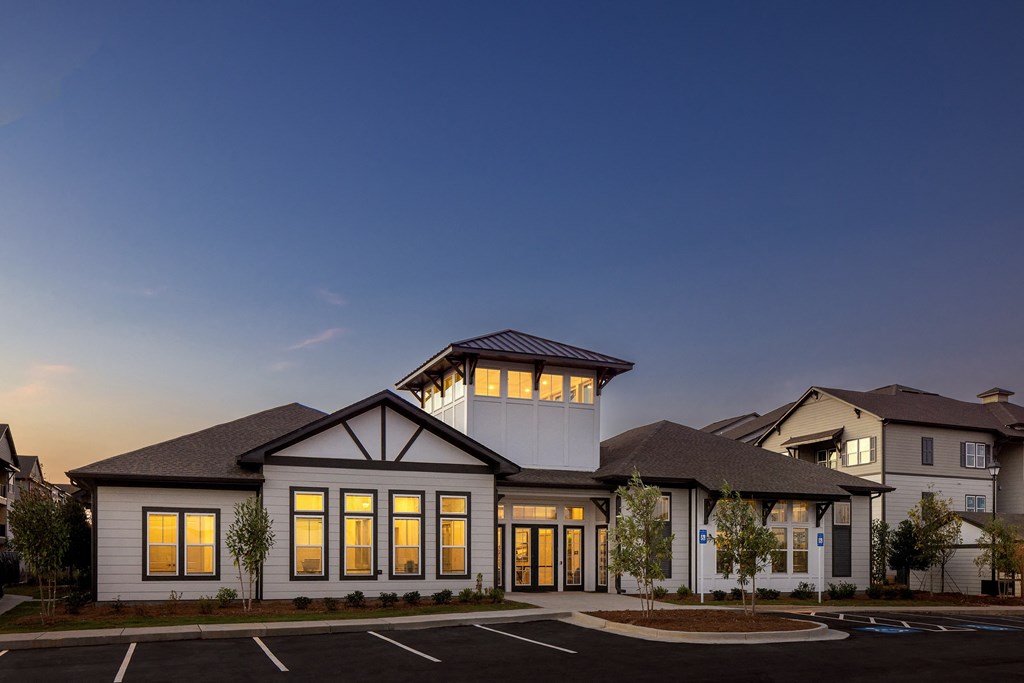 a rendering of a home at dusk with lights on in the windows