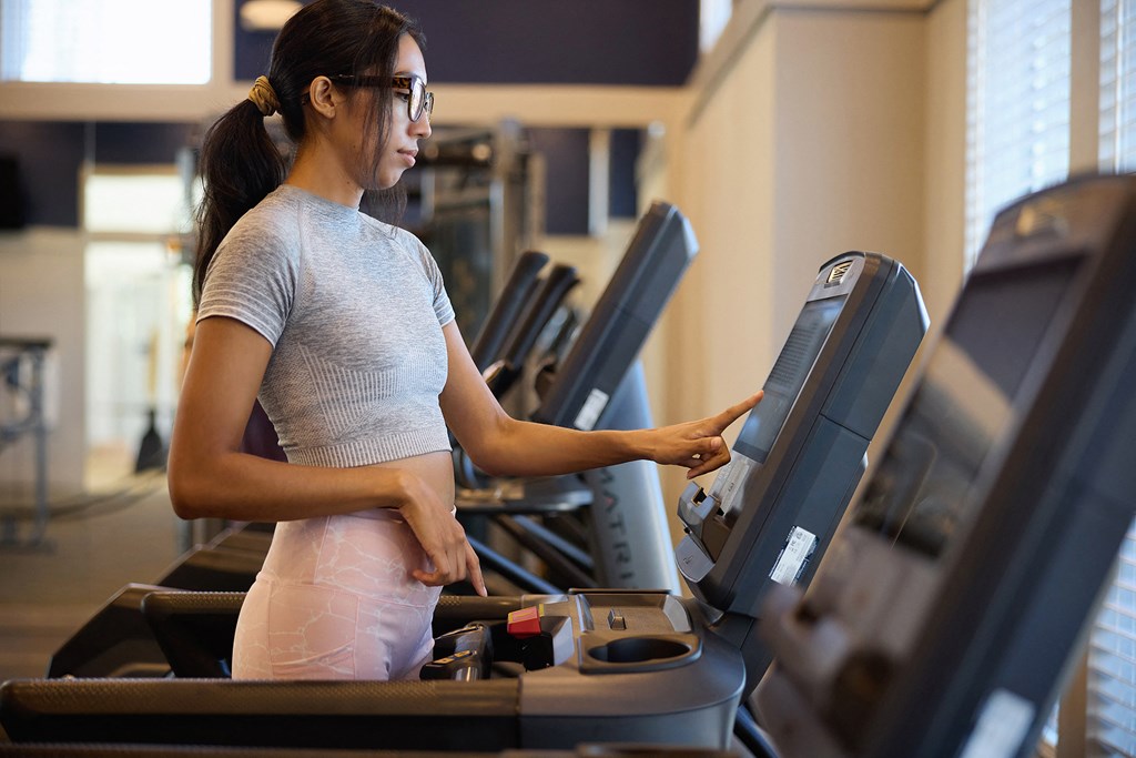 a woman running on a treadmill in a gym