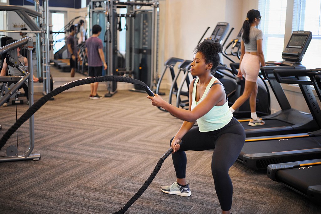 a woman is using a resistance rope in a gym