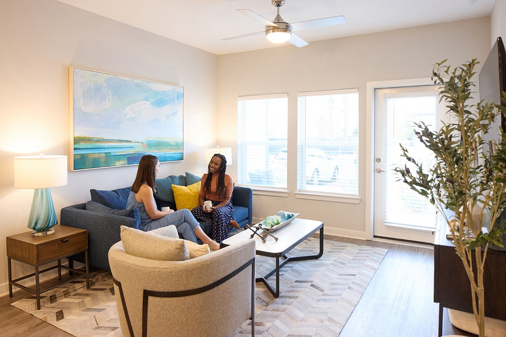two women sitting on a couch in a living room