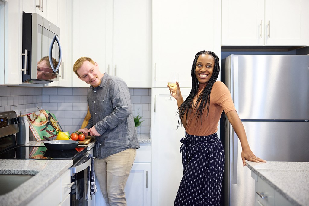 a man and woman in a kitchen preparing food