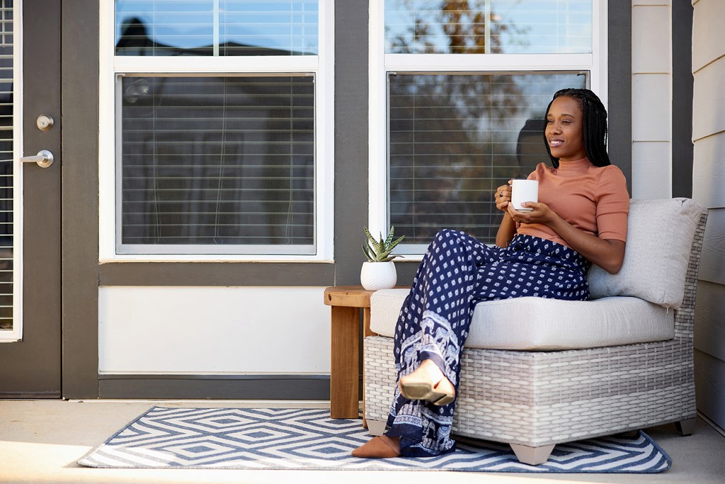 a woman sitting in a chair with a cup of coffee