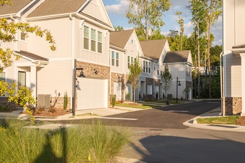 A row of houses with a tree in front of the first house.