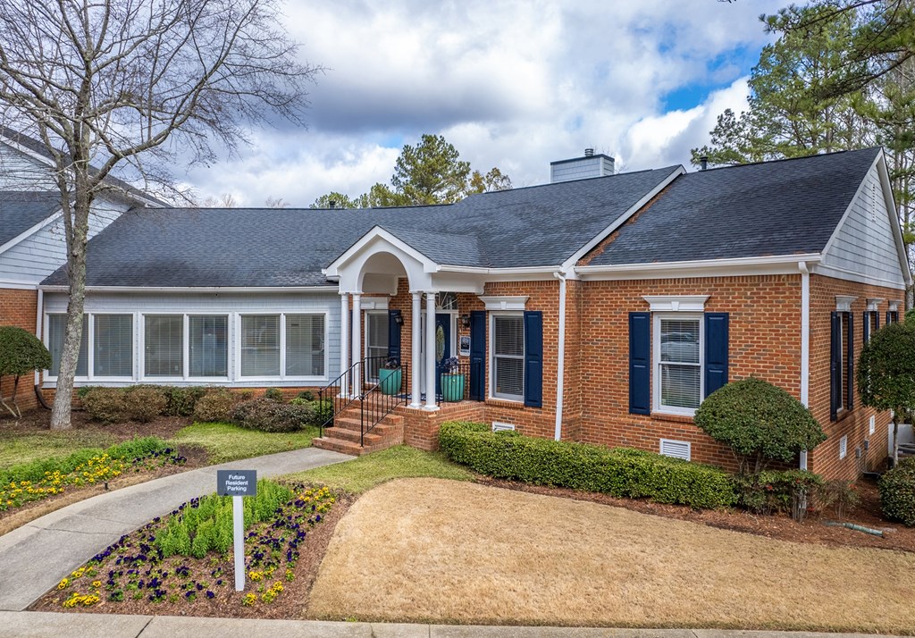 a brick house with a front yard and a sidewalk