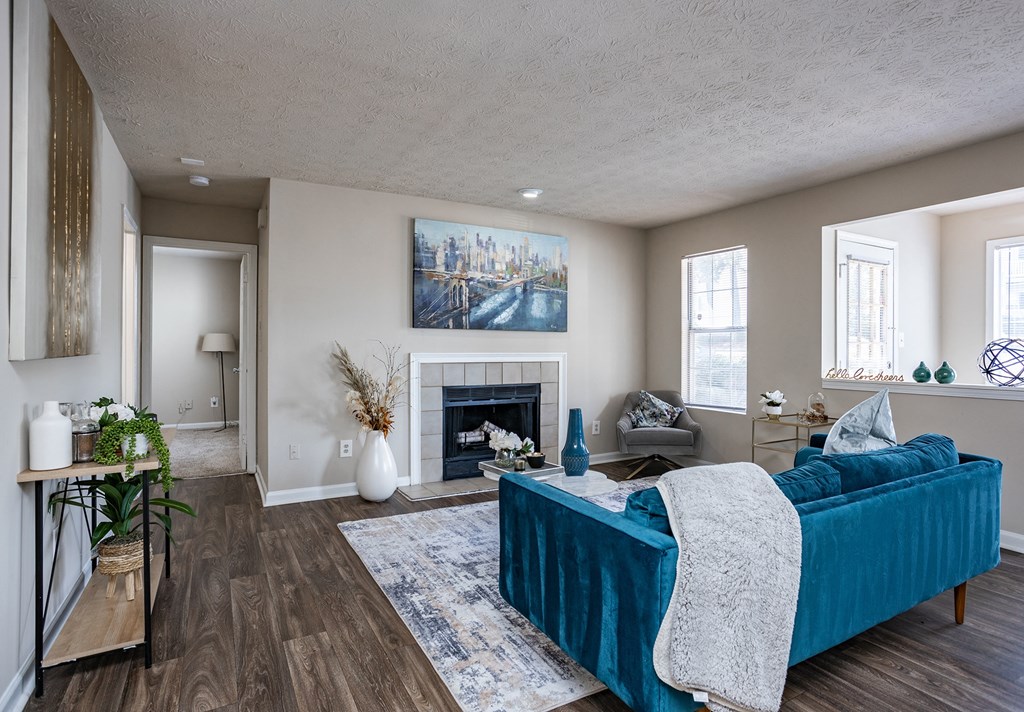 a living room with a blue couch and a fireplace