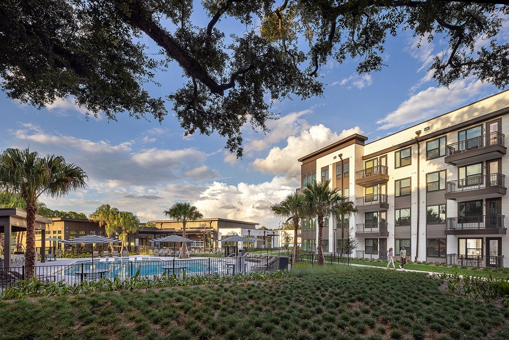 a rendering of apartment buildings and a pool at dusk