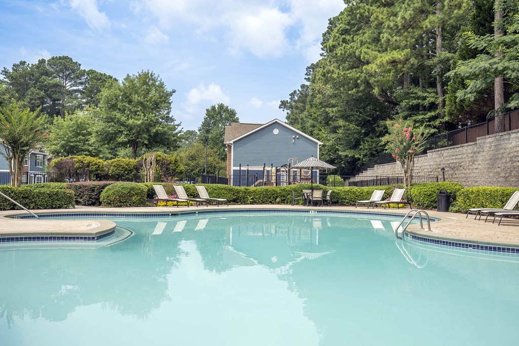 A swimming pool surrounded by trees and a house.