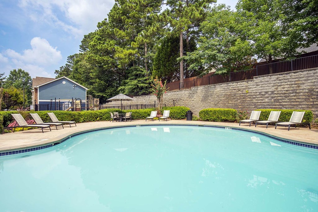 A swimming pool surrounded by trees and a building.