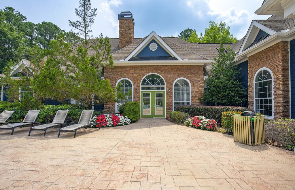 A brick house with a green door and a brick patio.