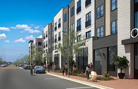 A street view of a residential area with apartment buildings and people walking on the sidewalk.