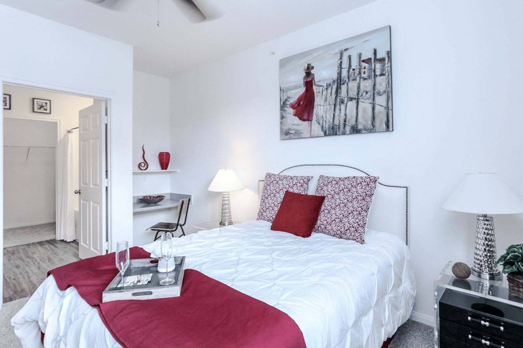 a bedroom with a white bed with red pillows