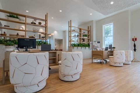 A modern office space with white furniture and wooden shelves.