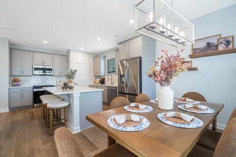 A modern kitchen with a dining table set for four.