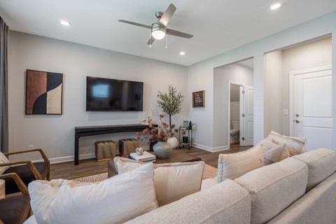 A living room with a white couch and a ceiling fan.