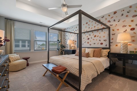 A bedroom with a four poster bed and a window with blinds.