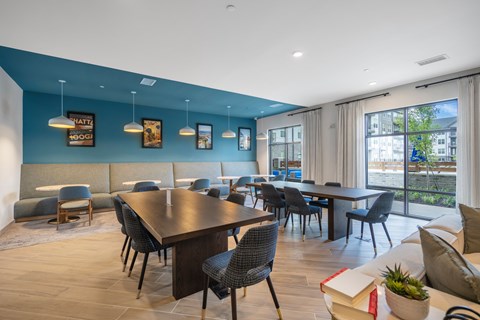 A modern dining room with a long table and chairs.