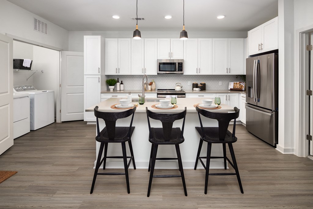 a kitchen with a center island with three bar stools
