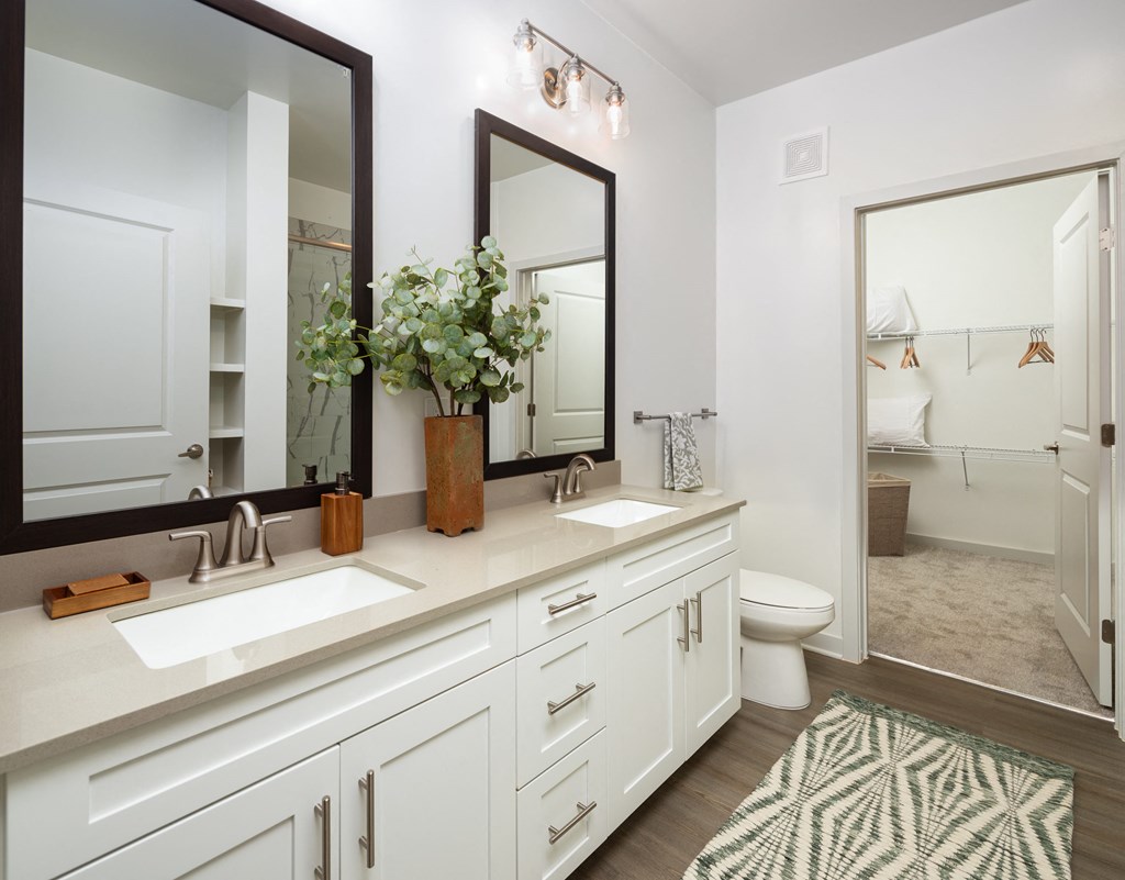 a white bathroom with two sinks and a mirror